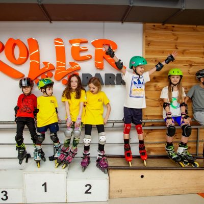 Grup de copii cu role, căști și protecții la Rollerdrome Chișinău